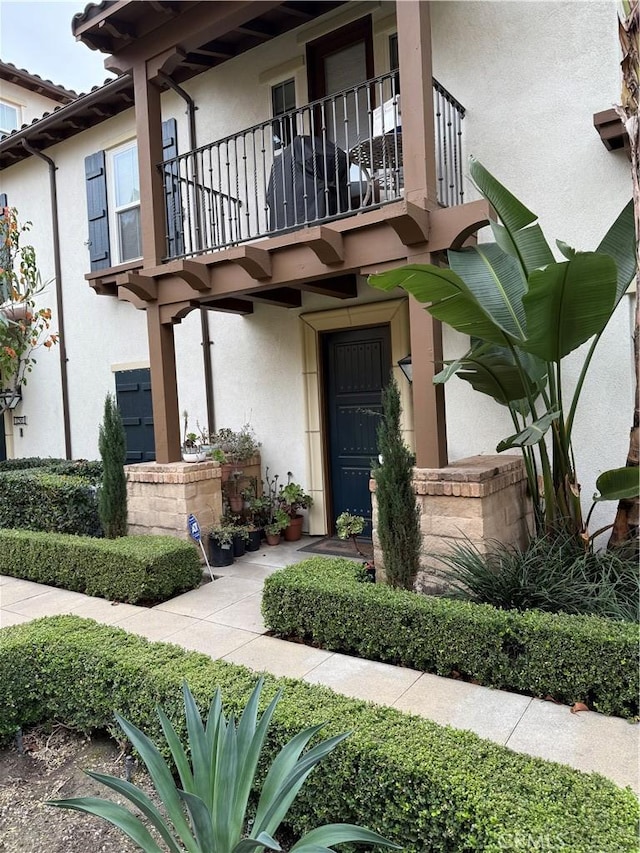 view of exterior entry with a balcony