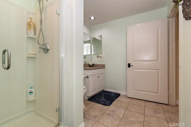 bathroom featuring tile patterned floors, vanity, toilet, and an enclosed shower