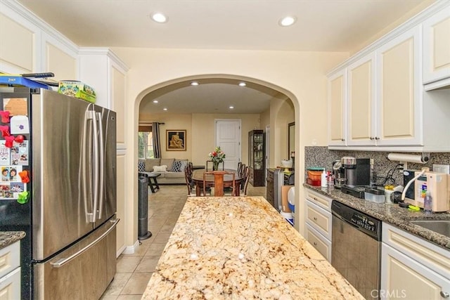 kitchen featuring light stone countertops, light tile patterned flooring, white cabinets, and appliances with stainless steel finishes