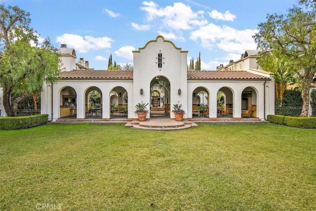 back of property with a yard and a patio area