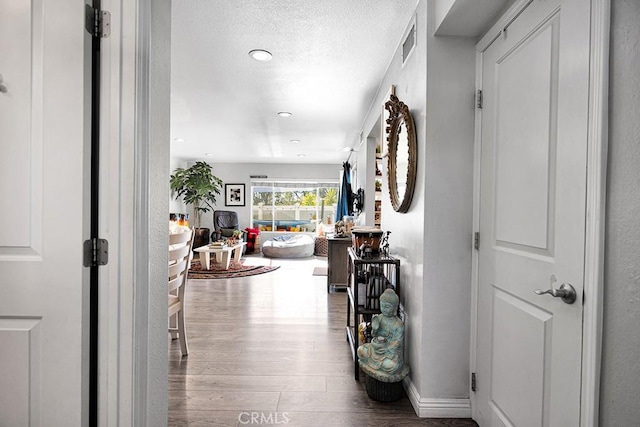 corridor featuring hardwood / wood-style flooring and a textured ceiling