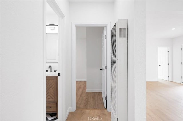 hall featuring sink and light hardwood / wood-style floors