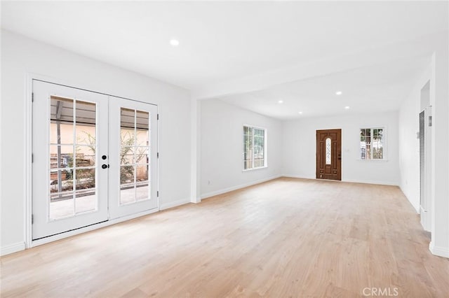 unfurnished living room with french doors and light hardwood / wood-style floors