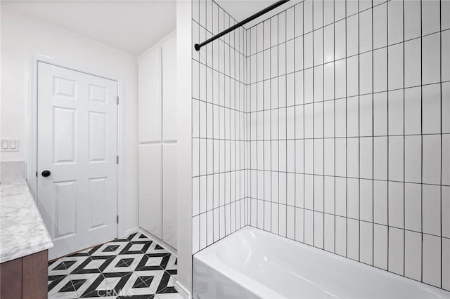 bathroom featuring tile patterned flooring, vanity, and tiled shower / bath combo