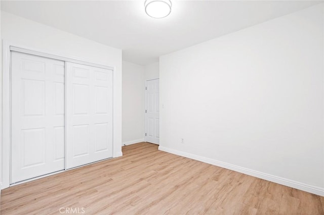 unfurnished bedroom featuring a closet and light wood-type flooring