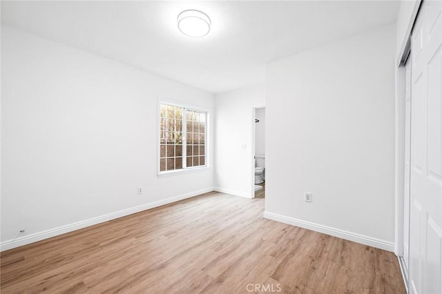 unfurnished bedroom with a closet and light wood-type flooring