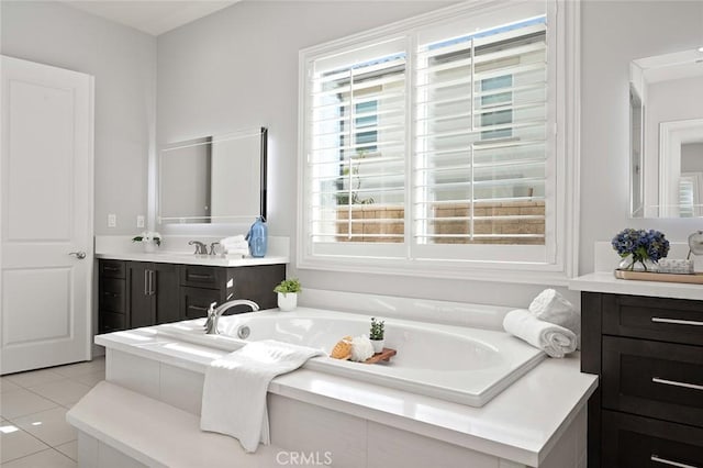 bathroom featuring tile patterned flooring, vanity, and a relaxing tiled tub