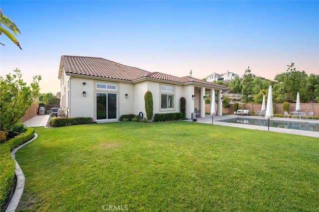 view of front of home with a fenced in pool and a yard