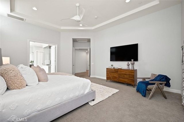 bedroom featuring a tray ceiling, carpet floors, and ceiling fan