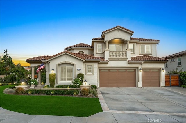 mediterranean / spanish-style home with a balcony, a garage, and a lawn