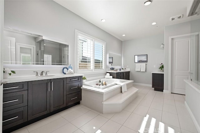 bathroom featuring tile patterned floors, tiled bath, and vanity