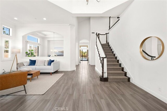 living room featuring crown molding, a notable chandelier, and hardwood / wood-style flooring