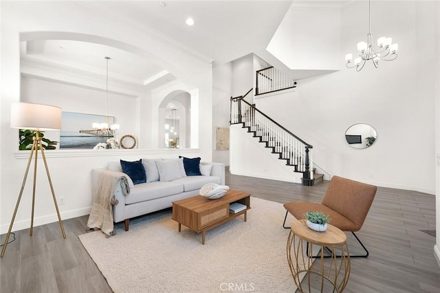 living room with crown molding, a chandelier, and hardwood / wood-style flooring