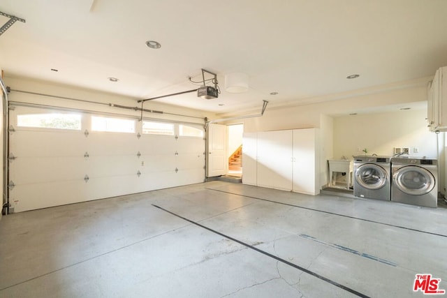 garage with separate washer and dryer and a garage door opener