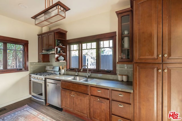 kitchen with appliances with stainless steel finishes, sink, dark wood-type flooring, and backsplash