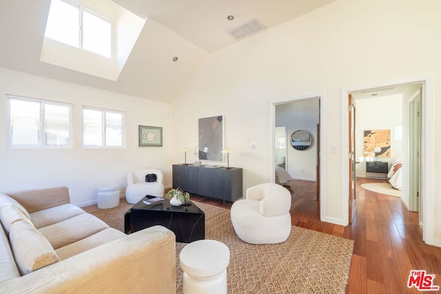 living room with hardwood / wood-style flooring and high vaulted ceiling