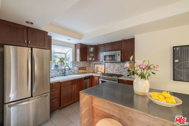 kitchen featuring light tile patterned floors, stainless steel appliances, sink, and backsplash