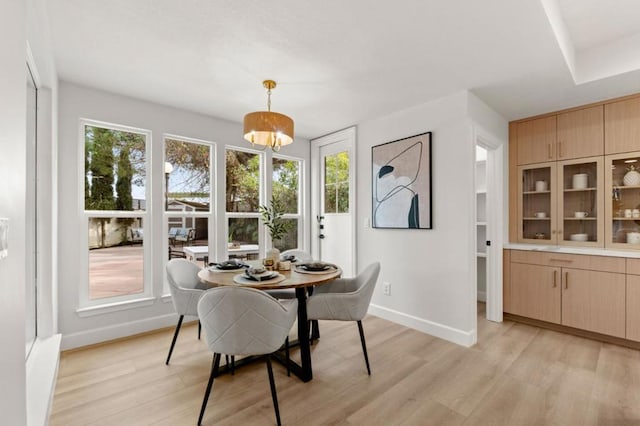 dining space with a chandelier and light hardwood / wood-style flooring