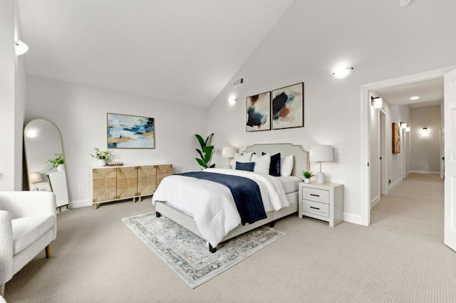 carpeted bedroom with high vaulted ceiling