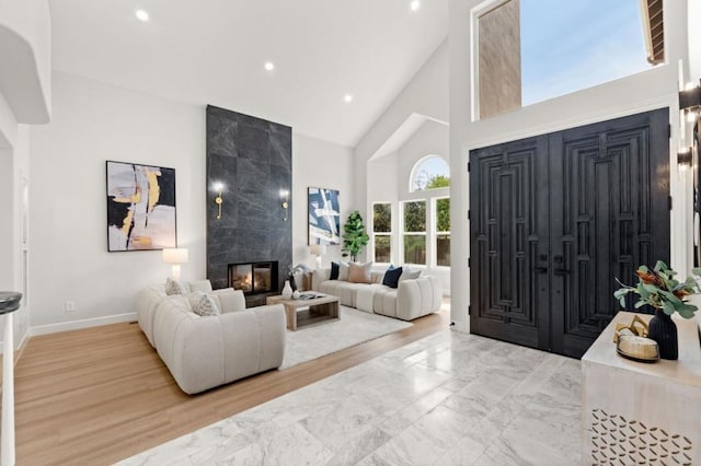 foyer with a high ceiling, light wood-type flooring, and a fireplace