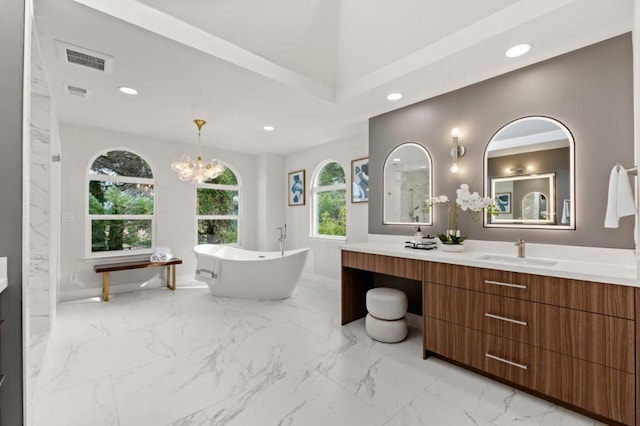 bathroom featuring vanity, a tub, and a chandelier