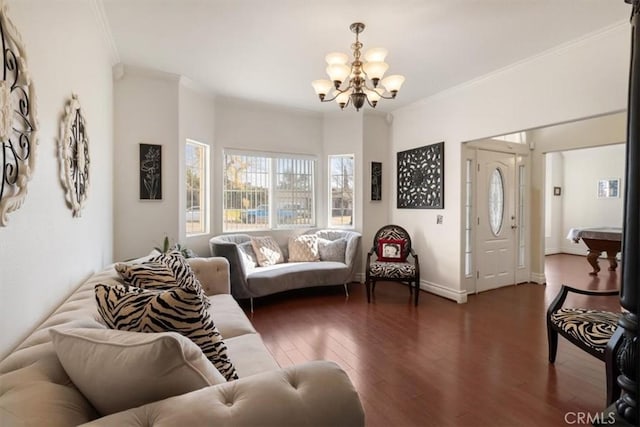 living area with ornamental molding, a notable chandelier, baseboards, and wood finished floors