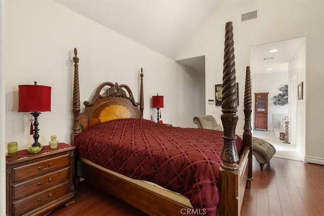 bedroom with lofted ceiling, visible vents, and dark wood-type flooring