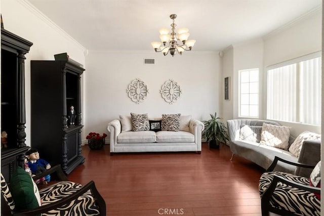 living room with ornamental molding, a chandelier, visible vents, and wood finished floors