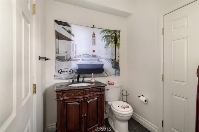 bathroom with toilet, baseboards, and vanity