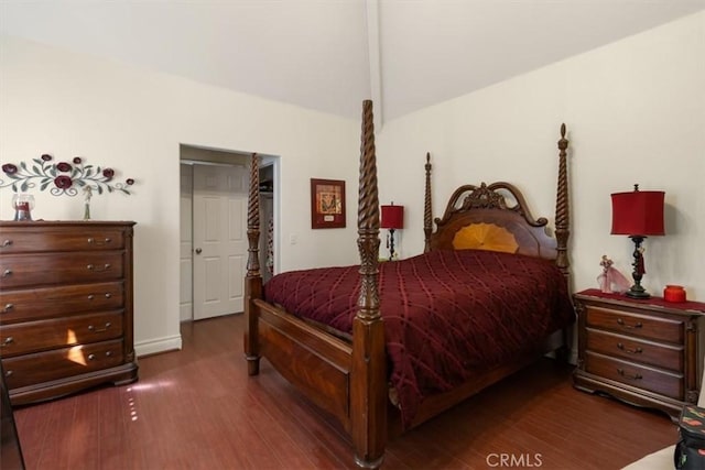 bedroom with vaulted ceiling and dark wood-style flooring