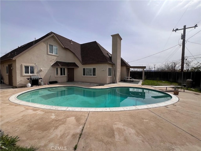 view of swimming pool featuring a fenced in pool, a patio, a grill, fence, and a diving board