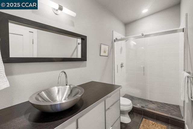 bathroom with vanity, tile patterned flooring, a shower with shower door, and toilet