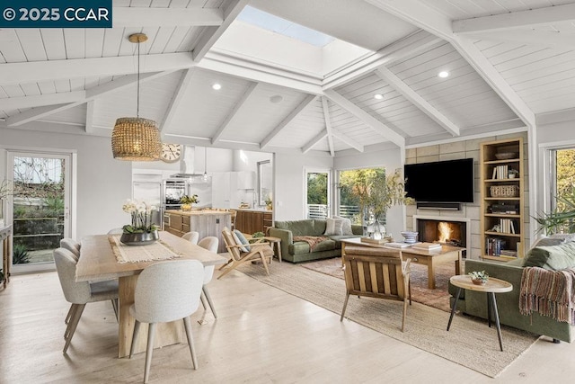 sunroom featuring a healthy amount of sunlight, a fireplace, and vaulted ceiling with skylight