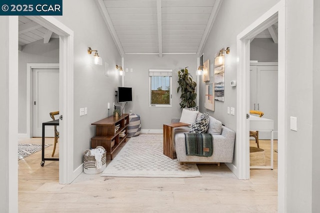 living room with beamed ceiling, wooden ceiling, crown molding, and light wood-type flooring