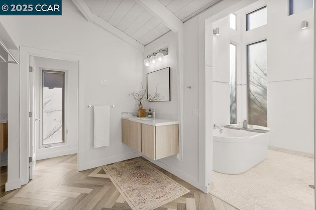 bathroom featuring vanity, parquet flooring, lofted ceiling with beams, and a bathing tub