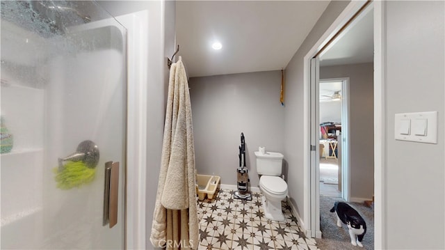 full bath featuring tile patterned floors, baseboards, toilet, and a walk in shower