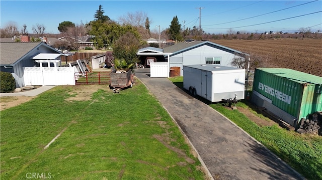 view of front of property with aphalt driveway, fence, and a front yard