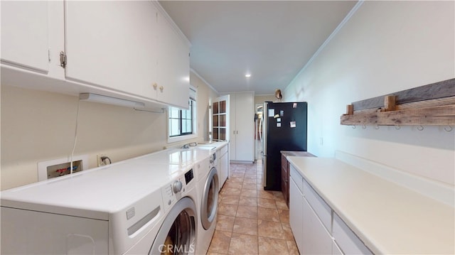 laundry area featuring a sink, cabinet space, ornamental molding, and washing machine and clothes dryer