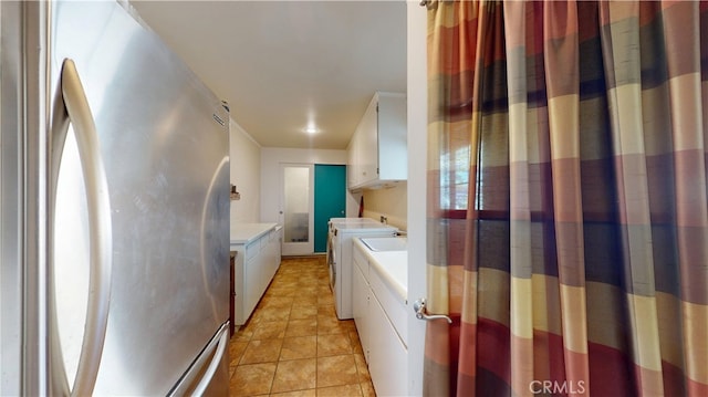 interior space with light tile patterned floors, laundry area, and washing machine and clothes dryer