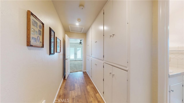 hallway featuring light wood-style flooring and baseboards