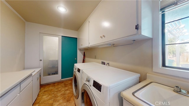 laundry room with separate washer and dryer, cabinet space, and a sink