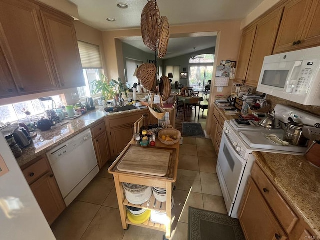 kitchen featuring a healthy amount of sunlight, light tile patterned floors, and white appliances