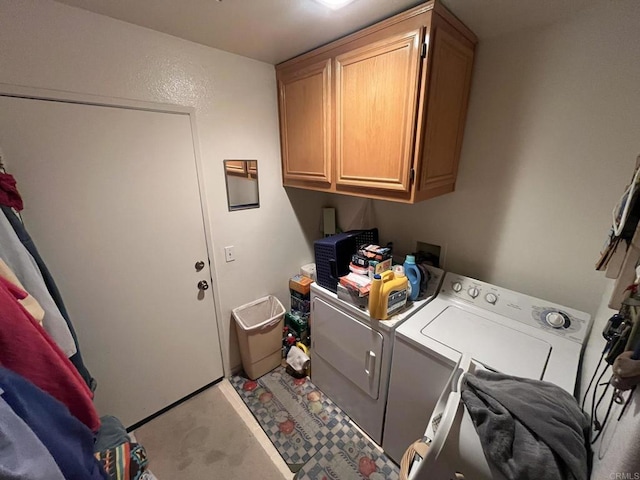 clothes washing area with cabinets and washer and clothes dryer