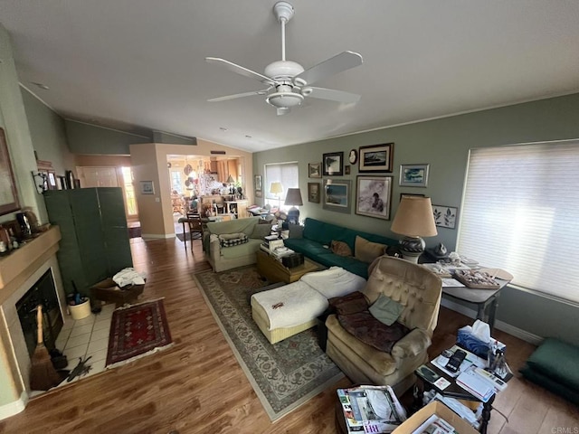 living room with hardwood / wood-style flooring, ceiling fan, lofted ceiling, and a wealth of natural light