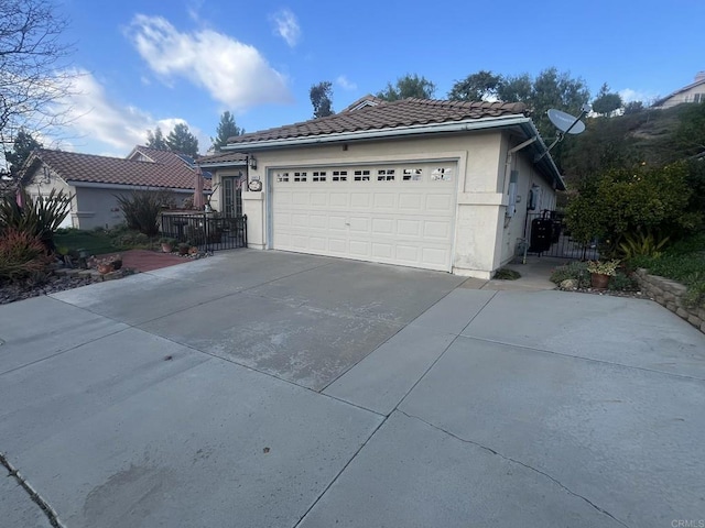 view of front of house featuring a tiled roof, driveway, and stucco siding