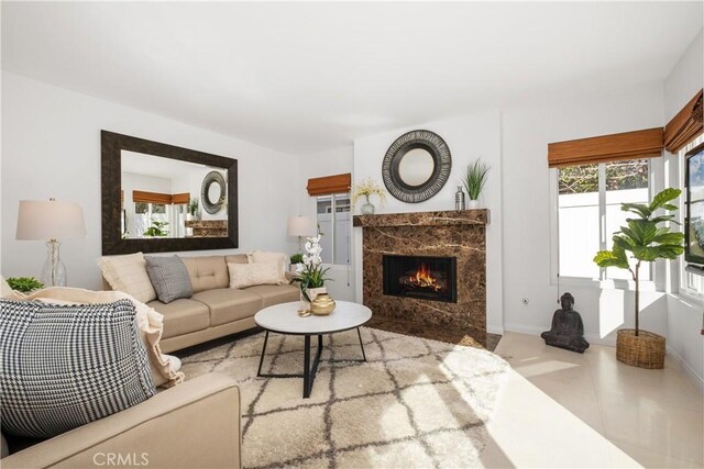 living room with light tile patterned flooring and a high end fireplace