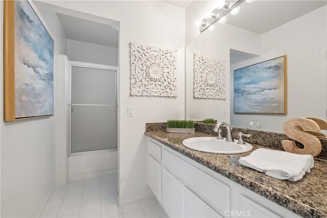 bathroom with tile patterned flooring, bath / shower combo with glass door, baseboards, and vanity