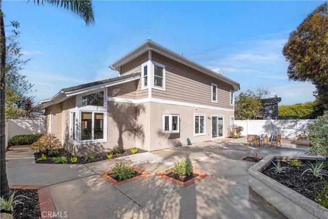 back of property featuring stucco siding, a patio, and fence