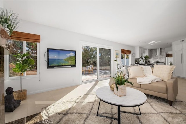 living area featuring light tile patterned floors and baseboards