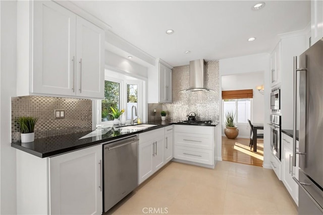 kitchen with white cabinets, sink, wall chimney exhaust hood, and appliances with stainless steel finishes